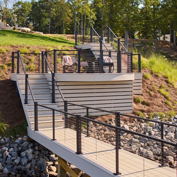 A path leading to the dock from the home made in the color Salt Flat and accented with Trex X-Series Cable Railing.